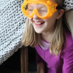 Venturing out of her fort with safety goggles for protection! 